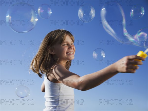 Young girl playing with bubbles