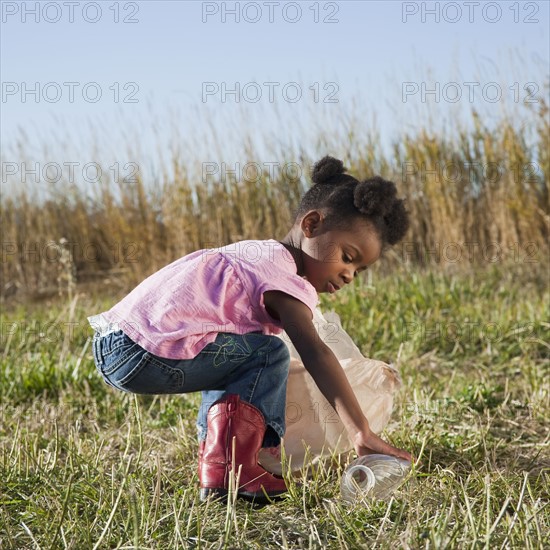 Young girl picking up litter