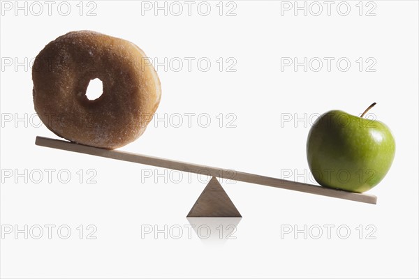 Donut and apple balanced on teeter totter