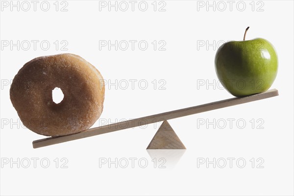 Donut and apple balanced on teeter totter