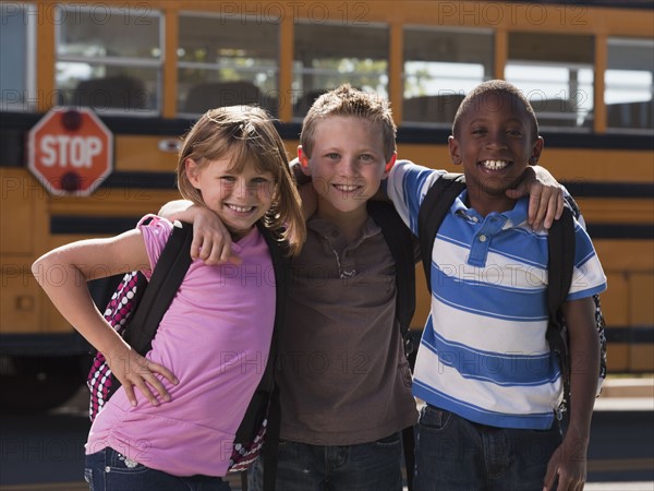 Friends in front of school bus