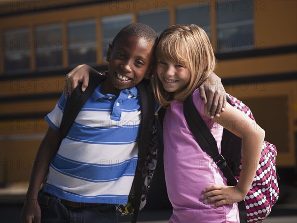 Friends in front of school bus