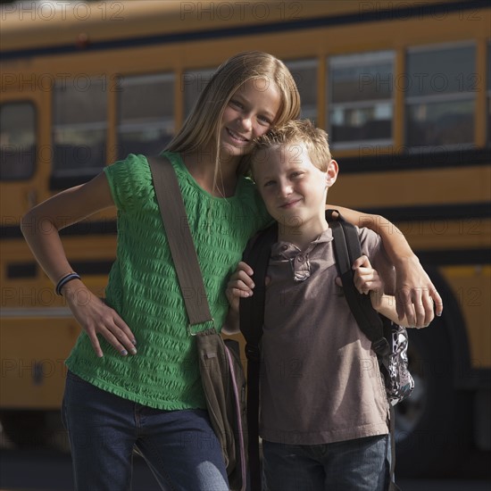 Friends in front of school bus