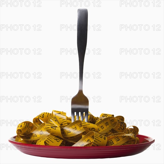 Measuring tape and fork on plate