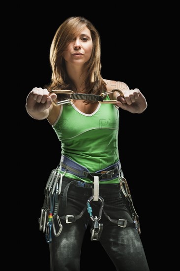 Studio shot of a female climber holding carabiners