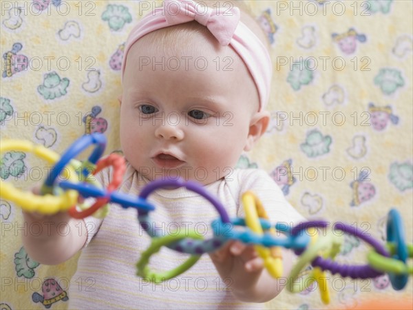 Portrait of baby girl playing with toy