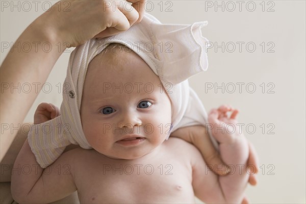 Hand changing baby's clothes