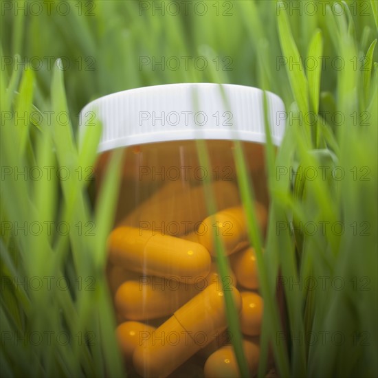 Bottle of pills in grass