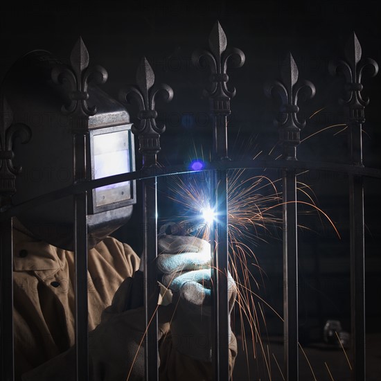 Steel worker welding a fence