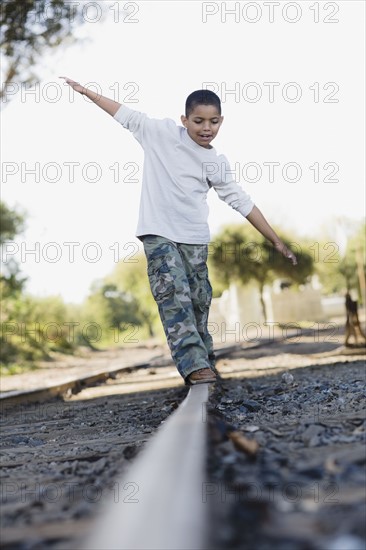 Boy walking on railroad track