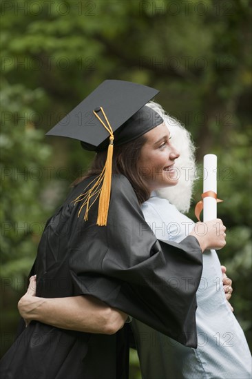 Graduate hugs elderly woman