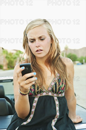 Woman leaning on car