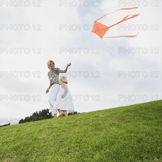 Mother and daughter flying kite