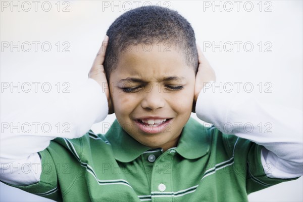 Boy with hands over ears