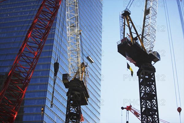 Cranes beside skyscraper