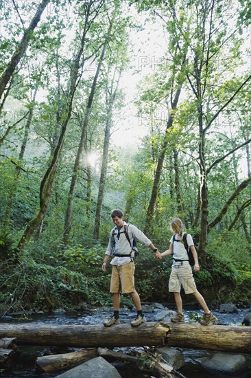 Hikers walking on log