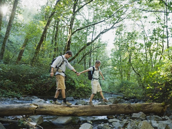 Hikers walking on log