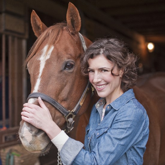 Woman holding horse.