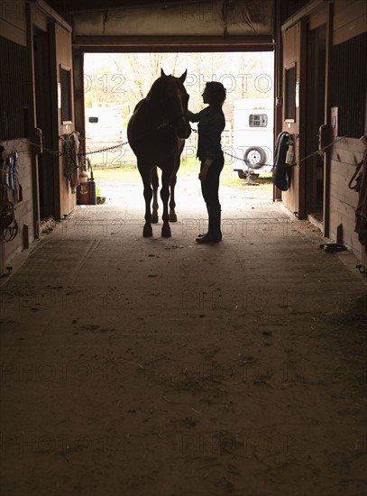 Woman grooming horse.