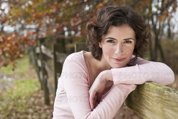 Woman leaning on fence.