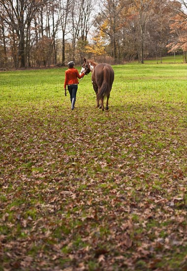 Woman walking with horse.