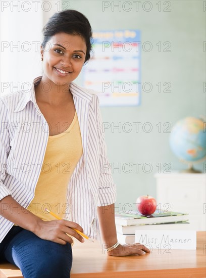 Teacher sitting on desk