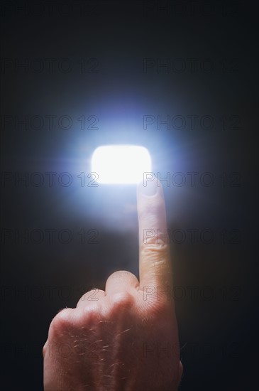 Finger pointing at light.