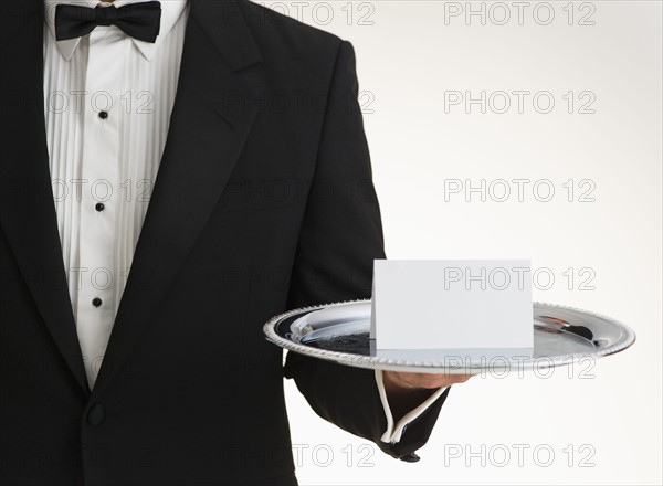 Butler holding silver tray.