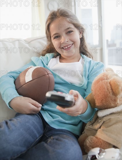 Young girl watching television. Photographer: Jamie Grill