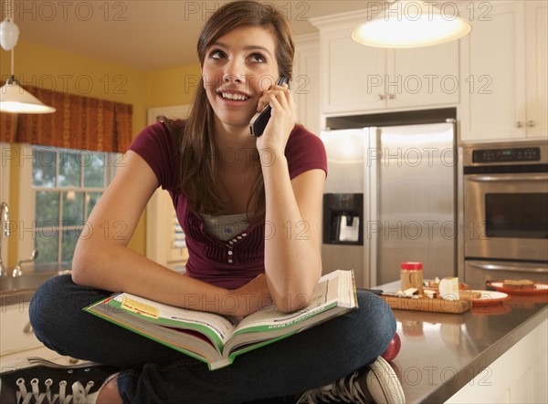 Girl sitting on kitchen counter. Photographer: mark edward atkinson