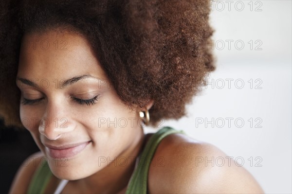 Portrait of a woman with her eyes closed. Photographer: momentimages