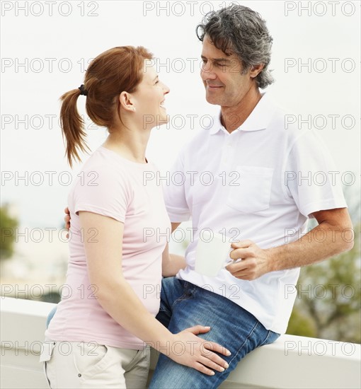 Couple relaxing on balcony. Photographer: momentimages