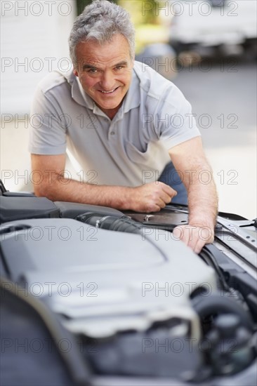 Man looking at car's engine. Photographer: momentimages