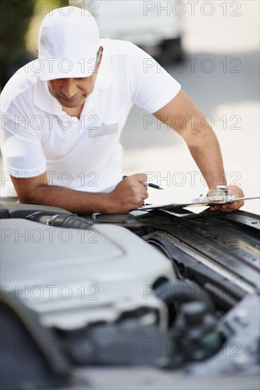 Man looking at car's engine. Photographer: momentimages