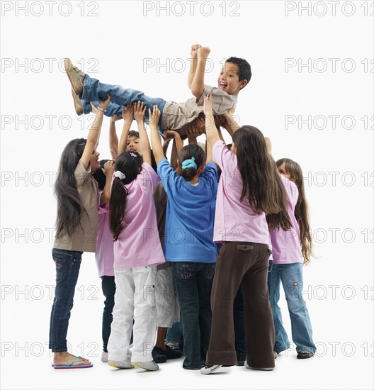 Children lifting one child. Photographer: momentimages