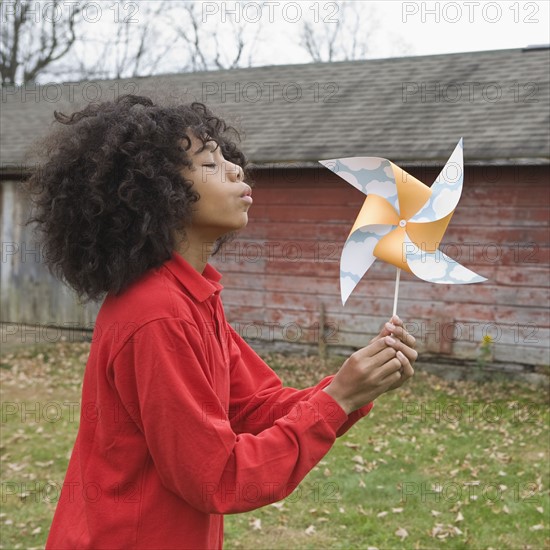 Girl blowing toy windmill. Photographer: Pauline St.Denis