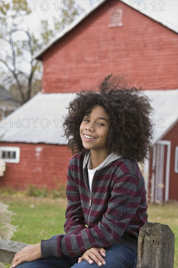 Child sitting on fence. Photographer: Pauline St.Denis