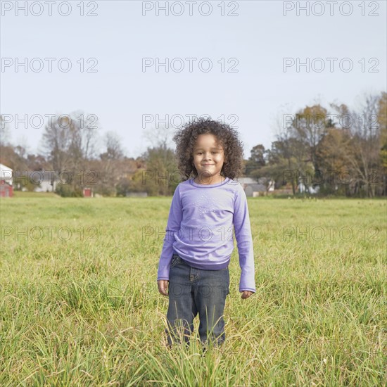 Young girl standing in meadow. Photographer: Pauline St.Denis