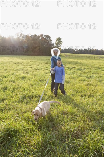 Boy walking dog on a leash. Photographer: Pauline St.Denis