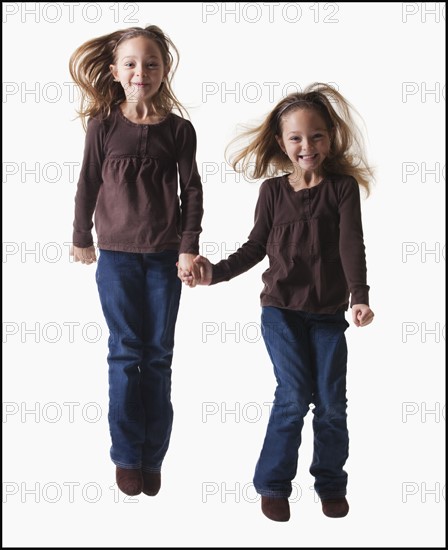 Identical twins jumping. Photographer: Mike Kemp