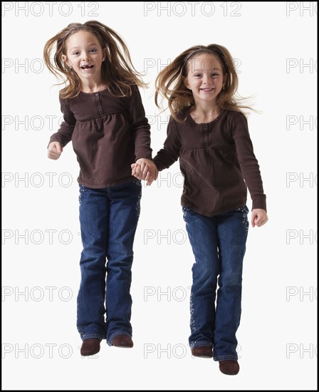 Identical twins jumping. Photographer: Mike Kemp