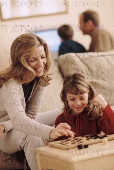 Mother and daughter playing checkers. Photographer: Rob Lewine