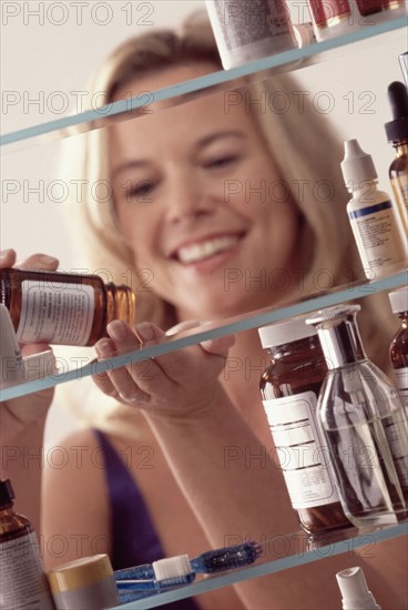 Woman in front of medicine cabinet. Photographer: Rob Lewine