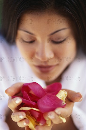 Woman holding flower petals. Photographer: Rob Lewine
