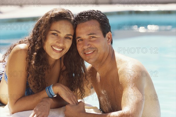 Couple relaxing by the pool. Photographer: Rob Lewine