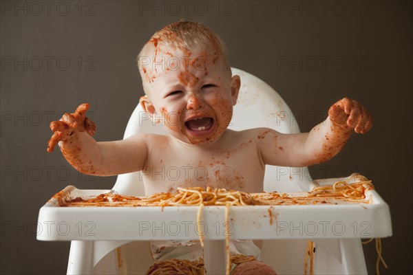 Baby covered in spaghetti. Photographer: Mike Kemp