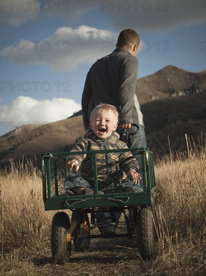 Father pulling son in wagon. Photographer: Mike Kemp