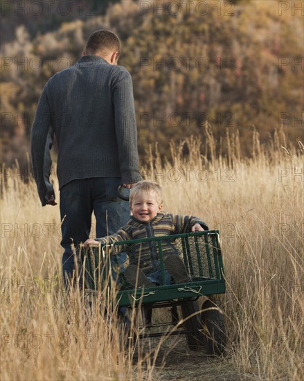 Father pulling son in wagon. Photographer: Mike Kemp