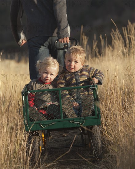 Father pulling children in wagon. Photographer: Mike Kemp