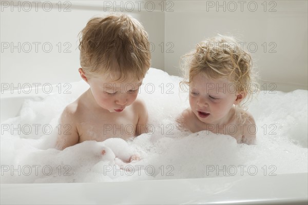 Children playing with bubbles in the bath tub. Photographer: Mike Kemp